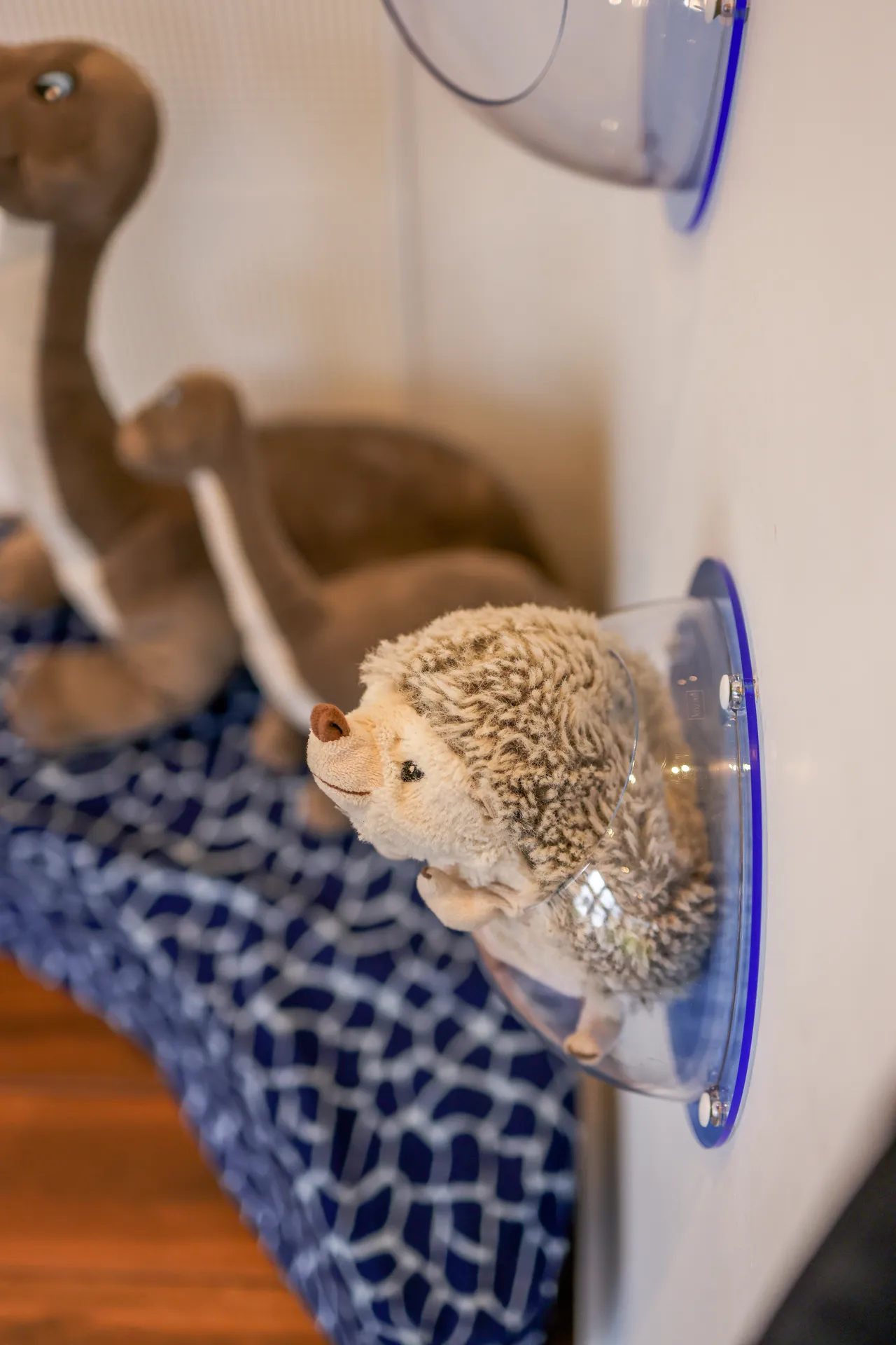 Kuscheltiere auf der blau gemusterten Sitzbank der Kinderecke